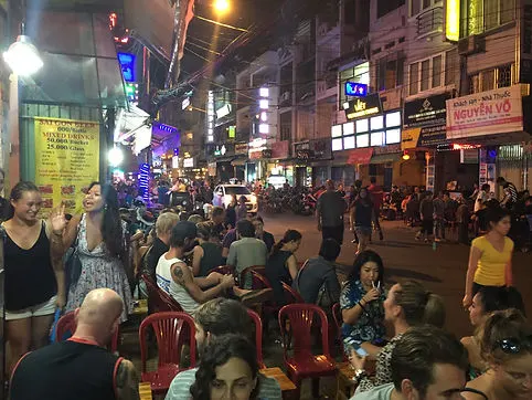 Travelers having a drink on Pham Ngu Lao Pub Street in Ho Chi Minh City, Vietnam