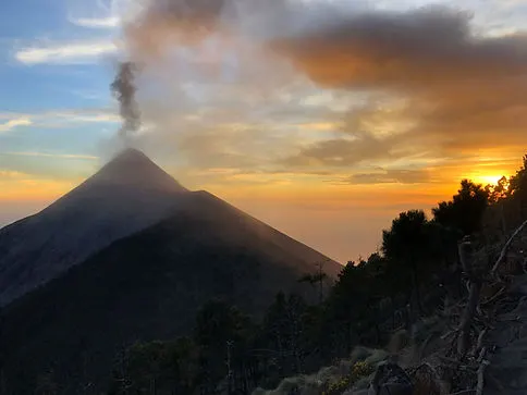 volcan fuego erupting smoke on the acatenango volcano hike near Antigua Guatemala during sunset