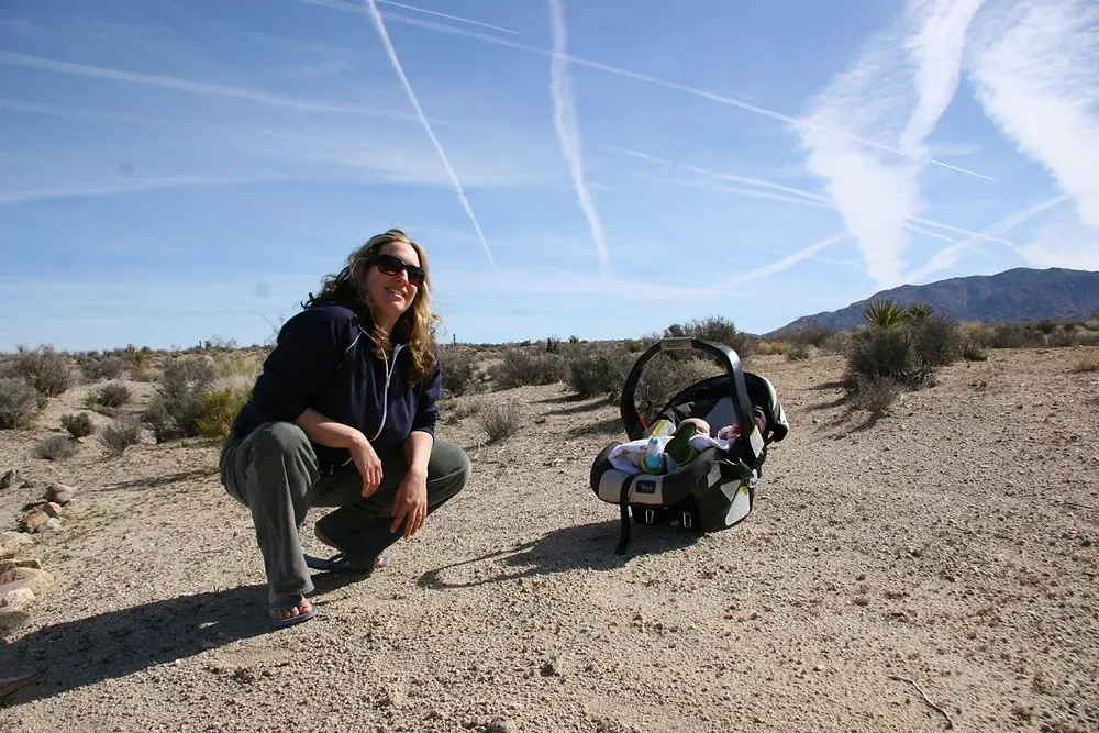 Meredith from Beautiful Voyager posing for a picture with her baby as a travel mom in Yosemite National Park