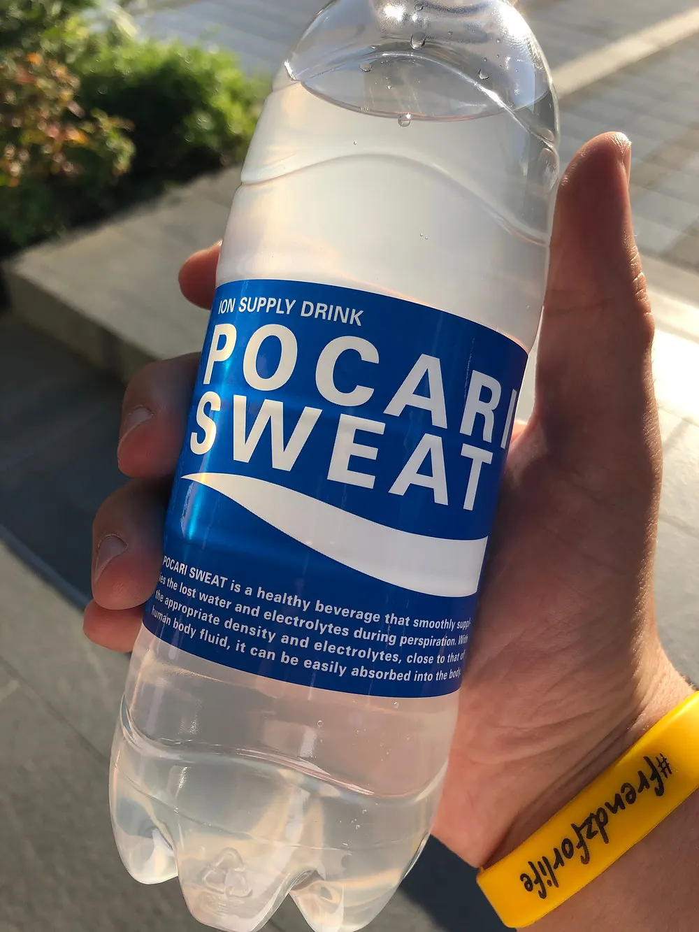 a traveler holding a bottle of Pocari Sweat, an electrolyte drink, in Tokyo Japan