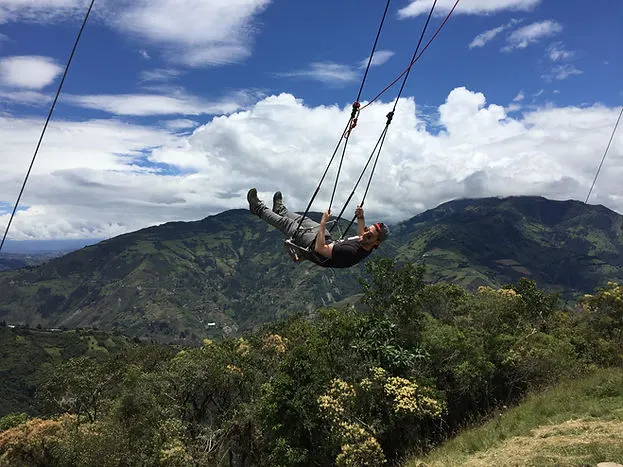 a male traveler on the swing at Casa de Arbol in Banos, Ecuador
