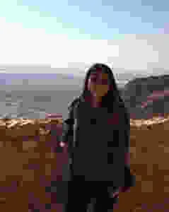 a female solo traveler poses for a picture in the American desert