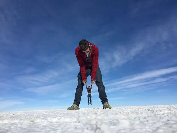 a forced perspective picture of a giant and tiny man at the Uyuni Salt Flats in Bolivia