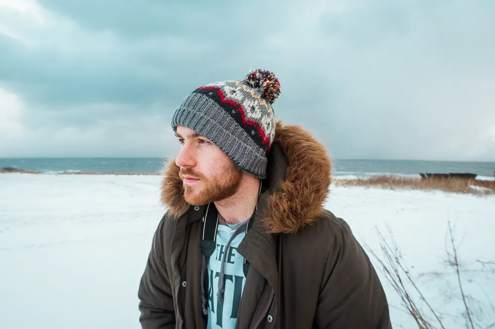 Steven of the Anxious Adventurer poses for a picture in Scotland in winter, wearing a beanie hat and a warm coat